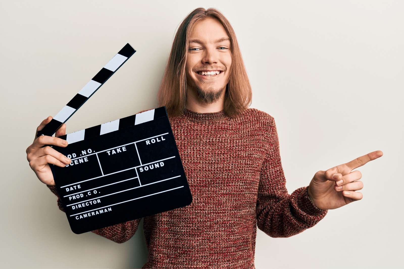 カチンコを持つ笑顔の男性